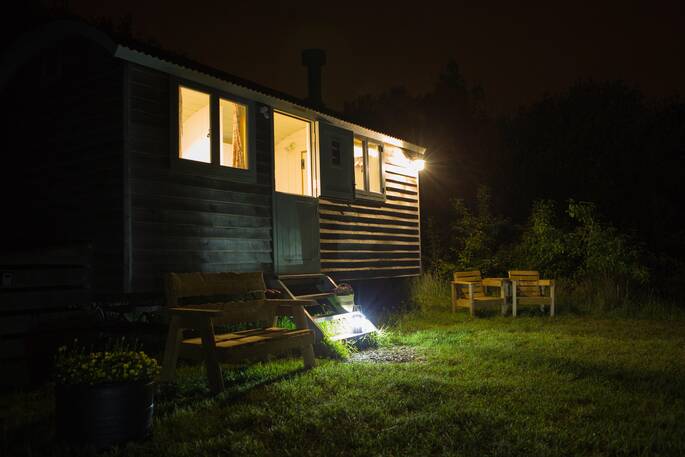Gwdihw shepherd's hut lit up at night