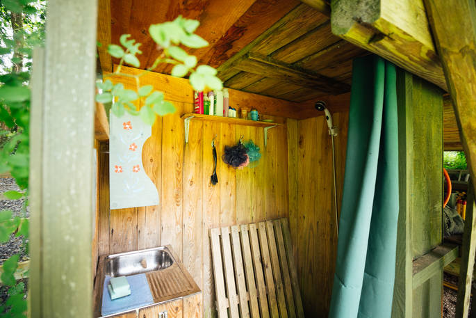 Rainwater gas-powered camping shower in the shower shed at The Log House Studio in Carmarthenshire