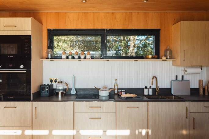 Kitchen equipped with an oven, microwabe, induction hub, kettle, toaster and cooking utensils