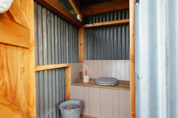 Bathroom with a hot shower, sink and compost loo