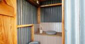 Bathroom with a hot shower, sink and compost loo