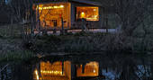 The Den cabin - during the night with reflection on the lake, One Cat Farm, Lampeter, Ceredigion, Wales