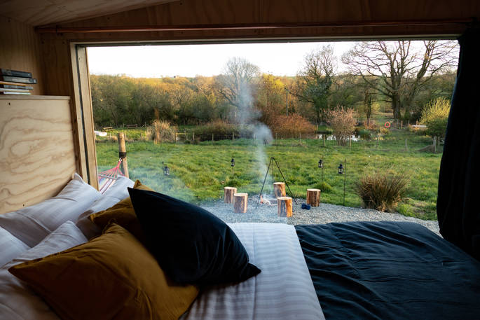 The Hide cabin - view from the bed to the fire pit BBQ, One Cat Farm, Lampeter, Ceredigion, Wales