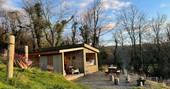 The Lookout cabin exterior with hammock pincnic table and fire pit BBQ, One Cat Farm, Ceredigion, Wales
