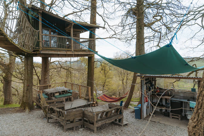 Copse camp is a treehouse with a kitchen, firepit area and dining area on the ground