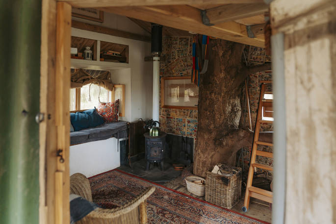 Living area has two day beds and a lounge area with a wood burner