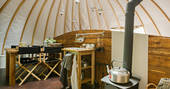Kitchen and dining area with logburner and kettle at Catta Dee, Penhein Glamping in Monmouthshire