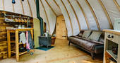 Cosy logburner, sofa bed and kitchen area at The Coombe tent, Penhein Glamping in Monmouthshire