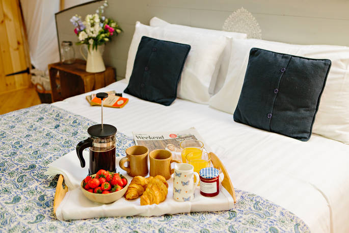 A delicious breakfast is served on the comfortable kingsize bed at The Cribbau, Penhein Glamping