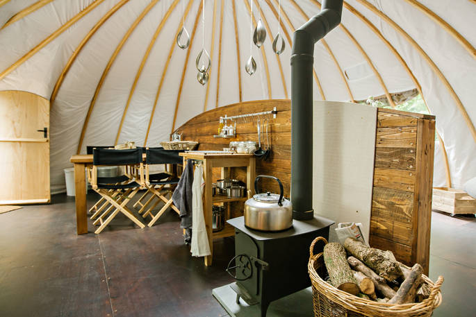 Keep warm by the cosy log burner inside The Oakes tent at Penhein Glamping
