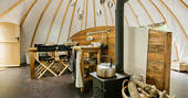 Keep warm by the cosy log burner inside The Oakes tent at Penhein Glamping