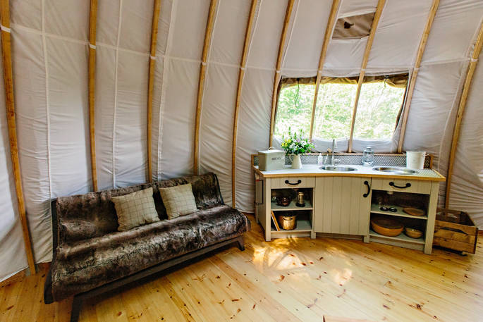 Fully-equipped kitchen area and sofabed at The Park tent, Penhein Glamping in Monmouthshire