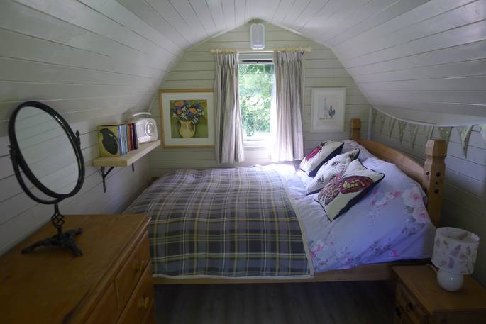 The comfortable and cosy double bed inside the glamping pod at Cwt Gwyrdd