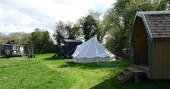 All the spaces at Cwt Gwrydd camp, which includes a shepherd's hut, bell tent and pod