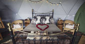 Double bed with flower petals in heart shape