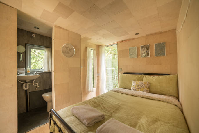 Double bed with en suite inside Beudy Banc Treehouse in Powys 
