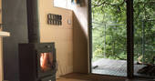 Light the wood-burner inside Beudy Banc Treehouse in Powys 