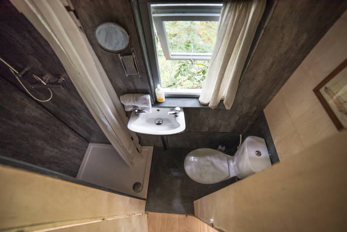 Shower and flushing toilet in the en suite inside Beudy Banc Treehouse in Powys 