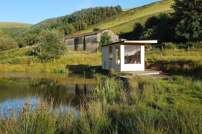 Caban Cilfa on the edge of a pond at Beudy Banc in Wales