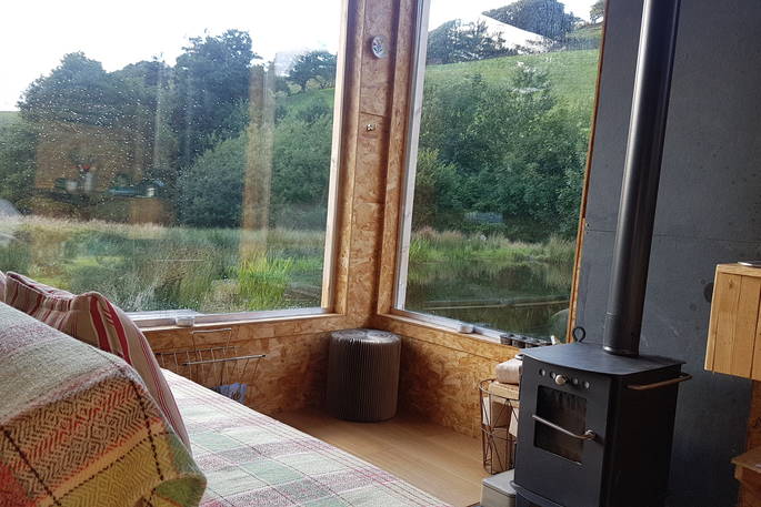 Interior of seating area and wood-burner at Caban Cilfa in Powys 