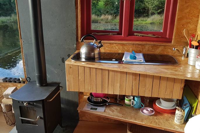 Interior of wood-burner and kitchen area inside Caban Cilfa cabin in Powys