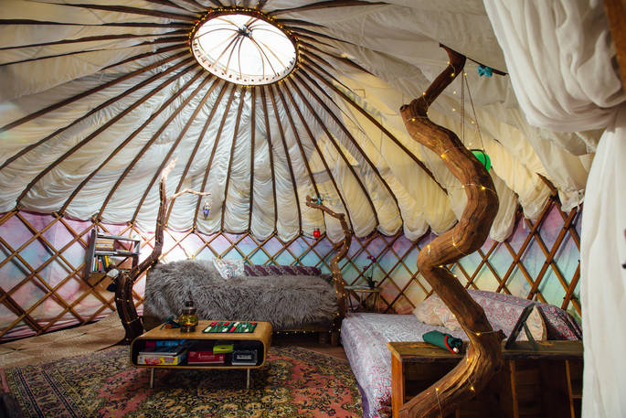 An inside view of Jericho Yurt with a warm bed and crafty wood structure.