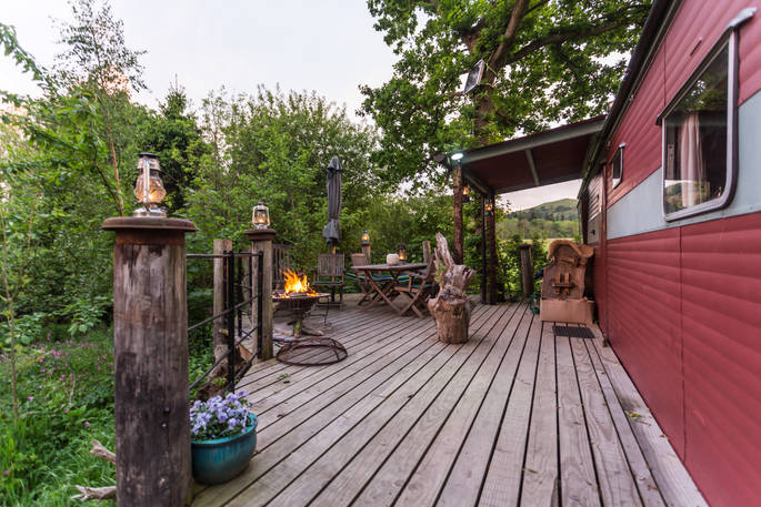 View of the outside decking of Van Goff cabin with fire pit and seating