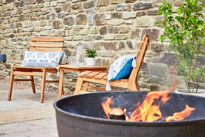 Enjoy the outdoors next to the roaring fire pit at The Burrow in Powys