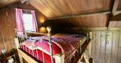 Double bed on mezzanine level inside the Duck Hut cabin 