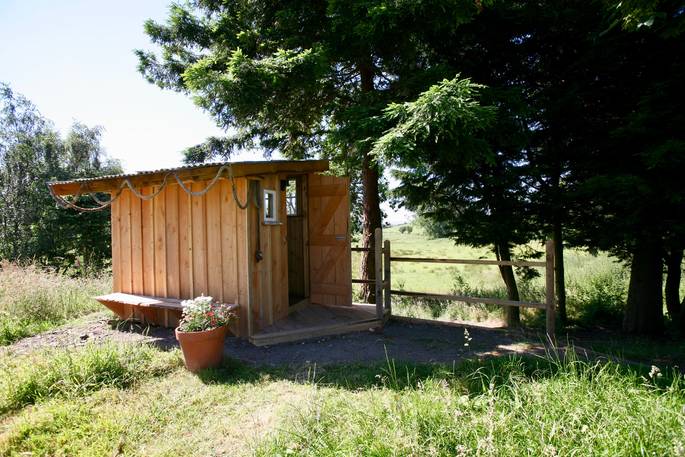 Exterior of the wooden shower shack for the Duck Hut cabin in Powys 