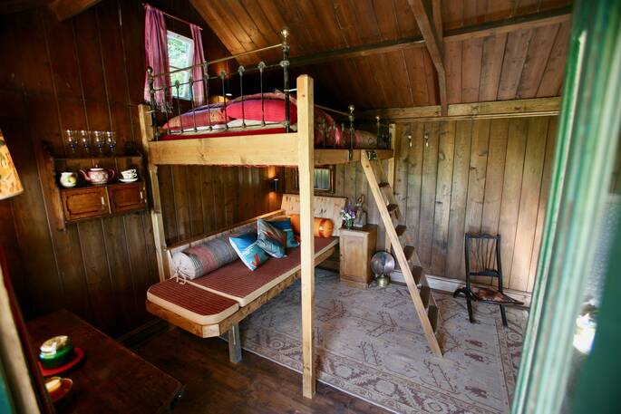 Wooden ladder leading up to the double bed on mezzanine level inside of the Duck Hut cabin in Powys 