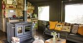 Open plan kitchen with a gas stove, small undercounter fridge and wood-fired oven