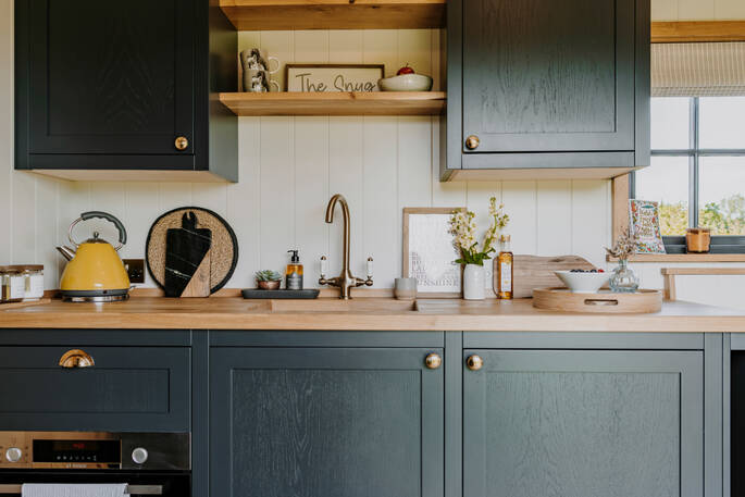 Kitchen equipped with an combi microwave oven, a portable induction hob, an undercounter fridgefreezer