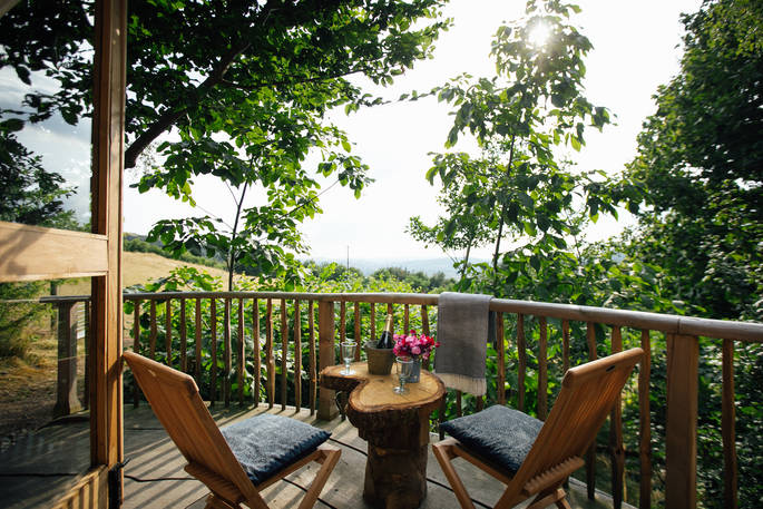 Enjoy a glass of wine on the decking as you admire the far-reaching views of the Powys countryside at Dragon's Cruck, Sunnylea