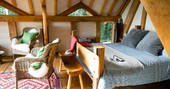 Comfortable kingsize bed and beautifully quirky furnishings inside Dragon's Cruck cabin at Sunnylea