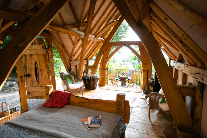 Inside Dragon Cruck cabin, with its cosy kingsize bed and incredible woodwork sourced from local timber