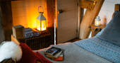 Relax with a good book in the cosy kingsize bed at Dragon Cruck, after a long day of exploring the Welsh countryside