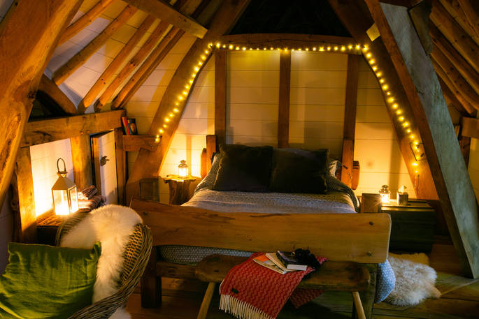 The cosy kingsize bed at Dragon Cruck, surrounded by fairy lights