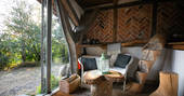 Inside The Sleepout cabin at Sunnylea, with table and chairs and views of the Powys countryside