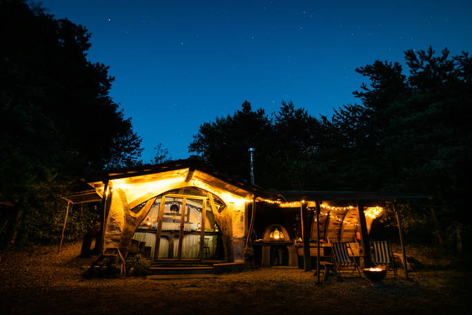 The beautifully rustic Sleepout cabin at Sunnylea near Powys, lit up at night