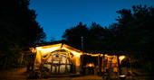 The beautifully rustic Sleepout cabin at Sunnylea near Powys, lit up at night