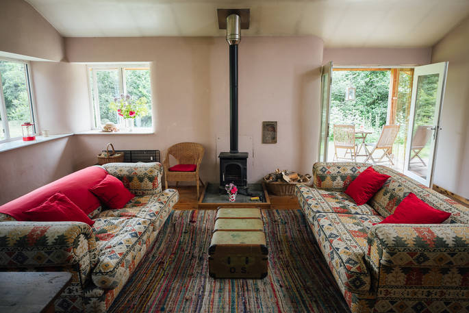 Get together with friends around the log burner at The Straw Cottage in Powys, Wales