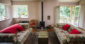 Get together with friends around the log burner at The Straw Cottage in Powys, Wales