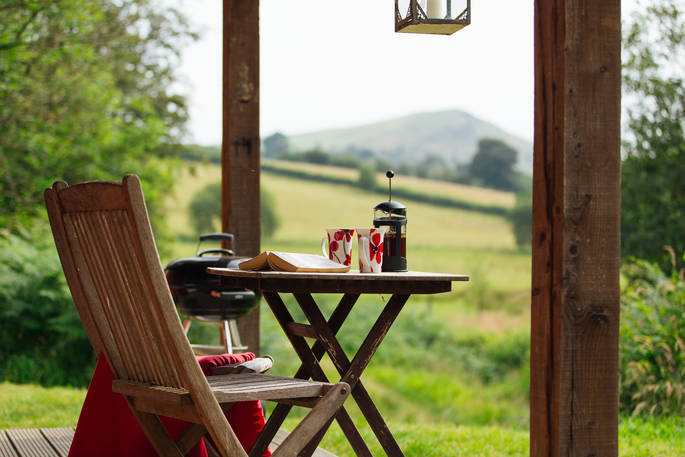 Sip your cup of coffee with views of the wood and mountains at The Straw Cottage in Powys, Wales