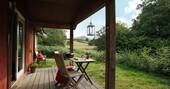 Sit on the covered decking and admire views of the valleys and mountains at The Straw Cottage in Powys, Wales