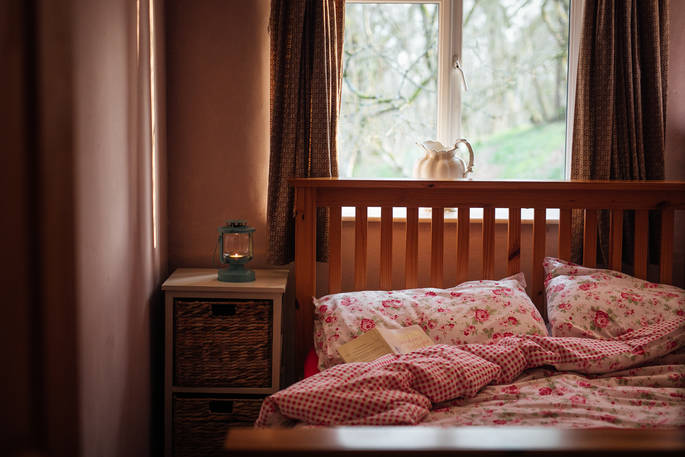 Tuck up in bed with a book at The Straw Cottage in Powys, Wales