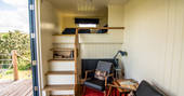 Interior of Pantechnicon Powys truck with stairs leading up to the king-size bed at Welsh Lavender 