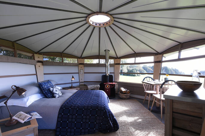 Cosy up in the double bed next to the wood-burner inside your Cabin at Hide at St Donats in Vale of Glamorgan 