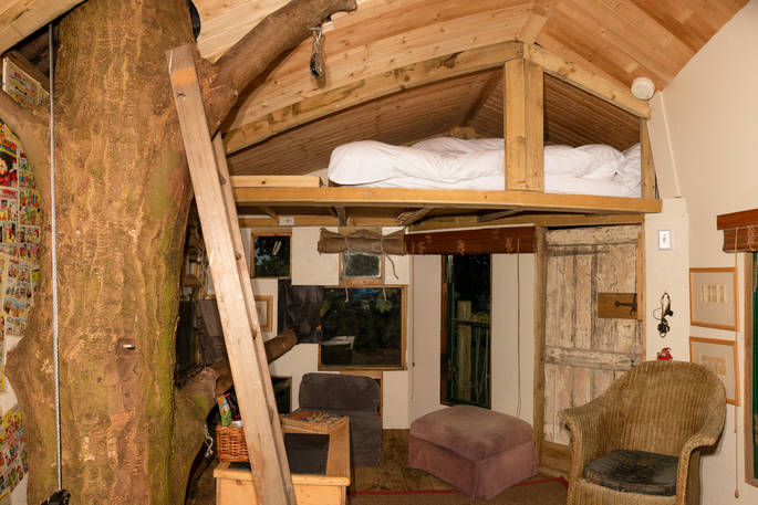 One double bed on mezzanine level with low attic type ceiling in the treehouse at copse camp 