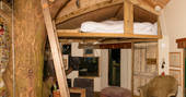 One double bed on mezzanine level with low attic type ceiling in the treehouse at copse camp 